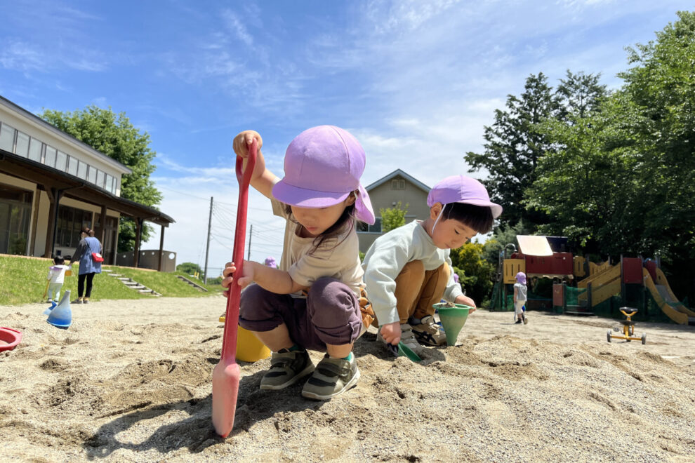 ひばりヶ丘保育園の園内、砂場で遊ぶ子供たちの様子